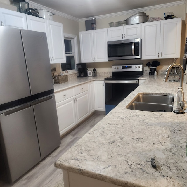 kitchen featuring white cabinetry, light hardwood / wood-style flooring, stainless steel appliances, and ornamental molding