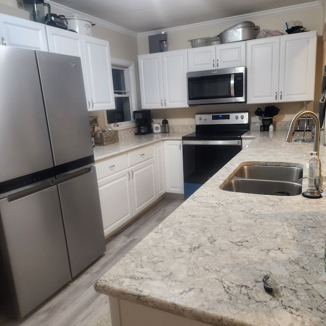 8789 Fowlerville Rd, Fowlerville, MI 48836 - kitchen with appliances with stainless steel finishes, a sink, white cabinetry, ornamental molding, and light wood finished floors