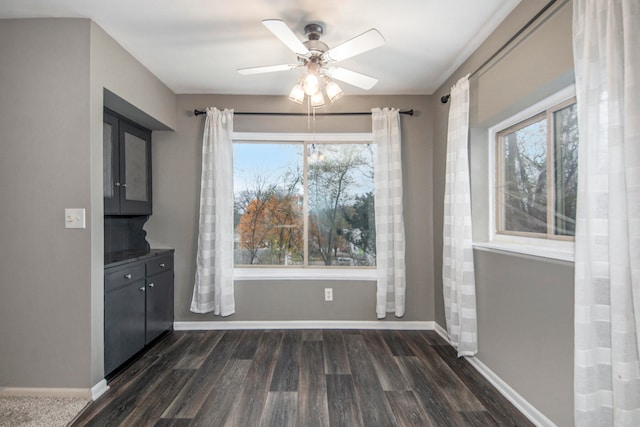 unfurnished dining area with dark hardwood / wood-style flooring, ceiling fan, and plenty of natural light