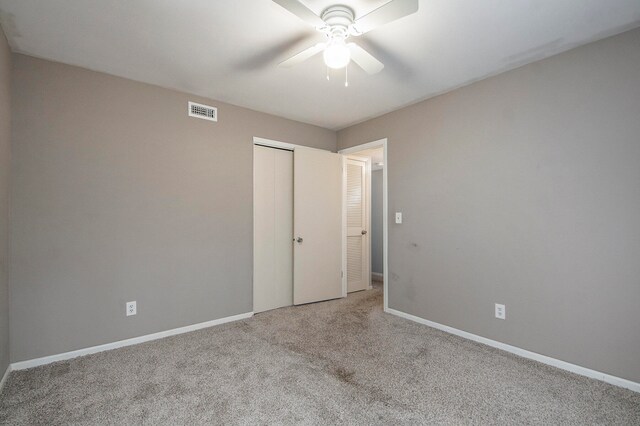 carpeted spare room featuring ceiling fan