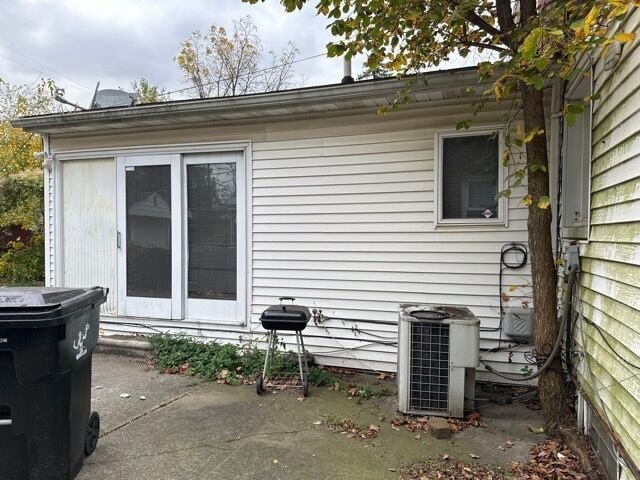 view of side of home featuring a patio area and cooling unit