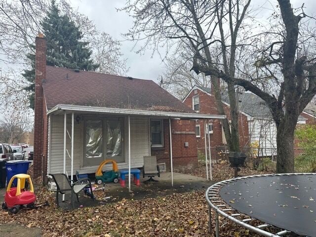 back of house with a trampoline