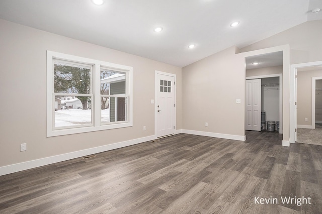 foyer entrance with dark hardwood / wood-style flooring and vaulted ceiling