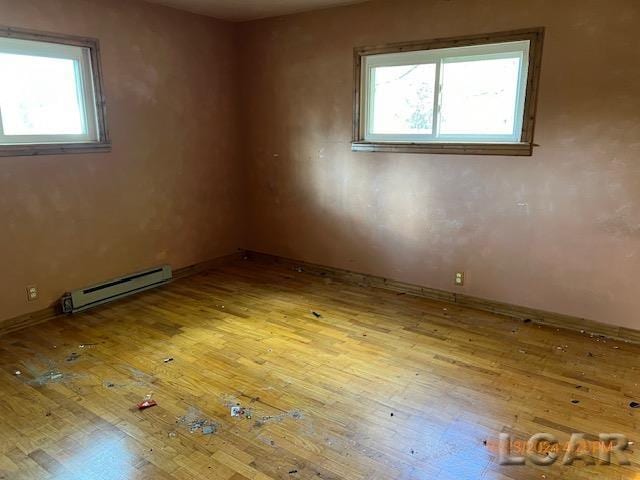 spare room featuring light wood-type flooring and a baseboard radiator