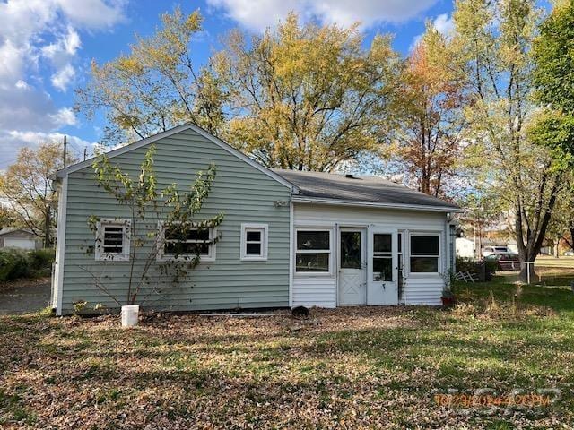 rear view of property featuring a yard