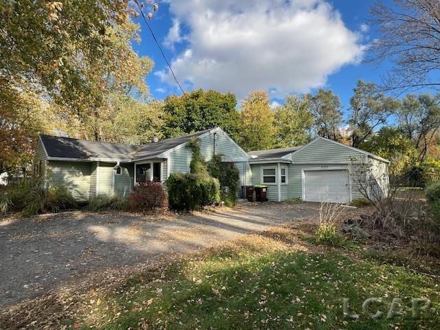 4209 Occidental Hwy, Adrian, MI 49221 - view of side of home featuring dirt driveway, a garage, and a chimney