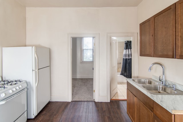 kitchen with white gas stove, dark hardwood / wood-style flooring, and sink