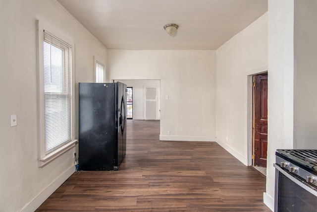 kitchen with black refrigerator, high end stainless steel range oven, and dark wood-type flooring