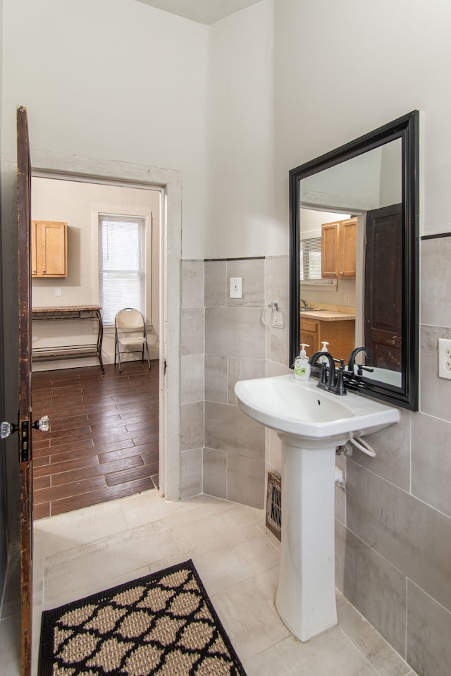 bathroom with hardwood / wood-style floors and tile walls