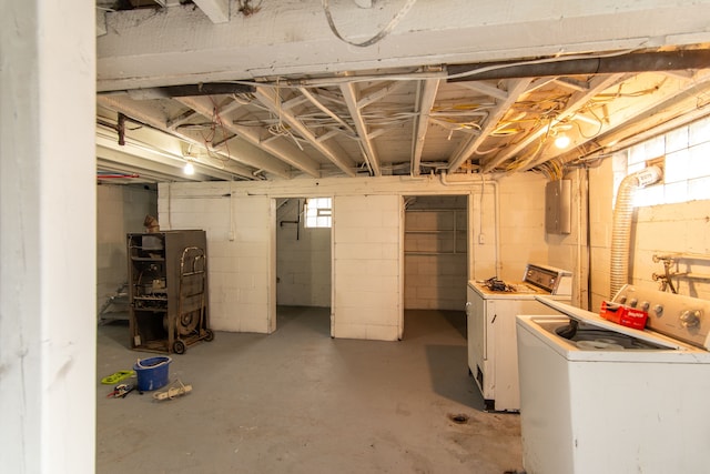 basement with electric panel and washer and clothes dryer