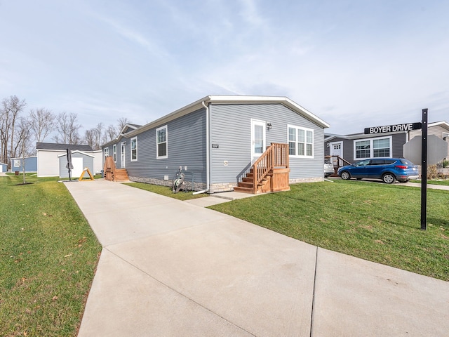 manufactured / mobile home featuring an outbuilding, a front yard, and a garage