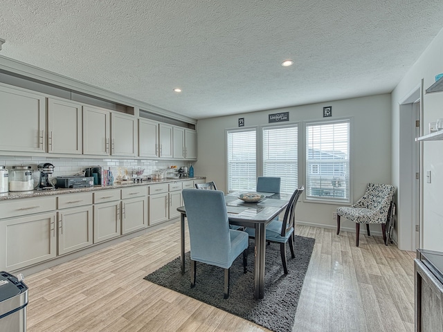 dining room with a textured ceiling and light wood-type flooring