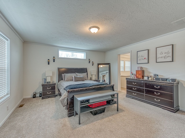 bedroom featuring a textured ceiling, light colored carpet, ornamental molding, and connected bathroom