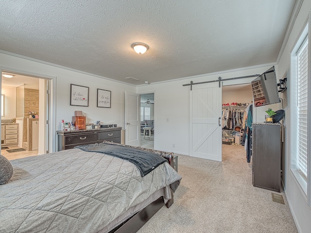 carpeted bedroom featuring a walk in closet, a barn door, multiple windows, and a closet