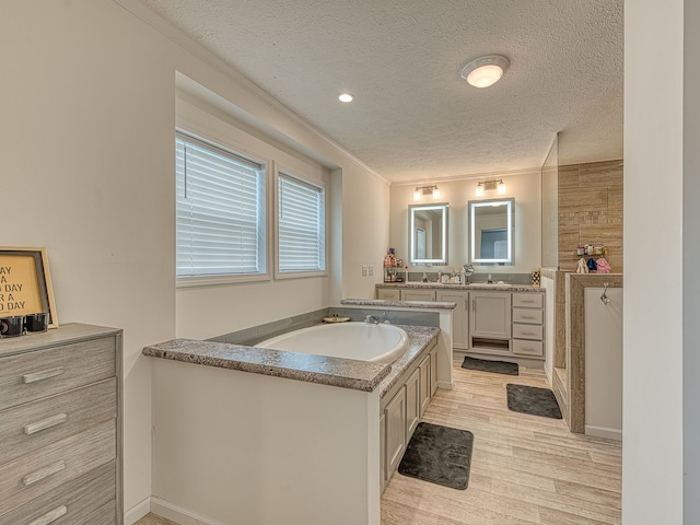 bathroom with vanity, wood-type flooring, a textured ceiling, and crown molding