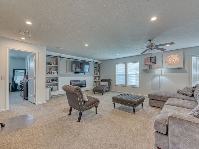 carpeted living room with ceiling fan and a textured ceiling