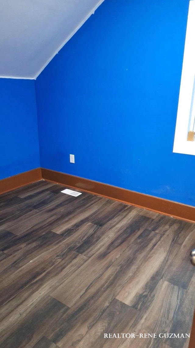 interior space featuring lofted ceiling and dark hardwood / wood-style floors