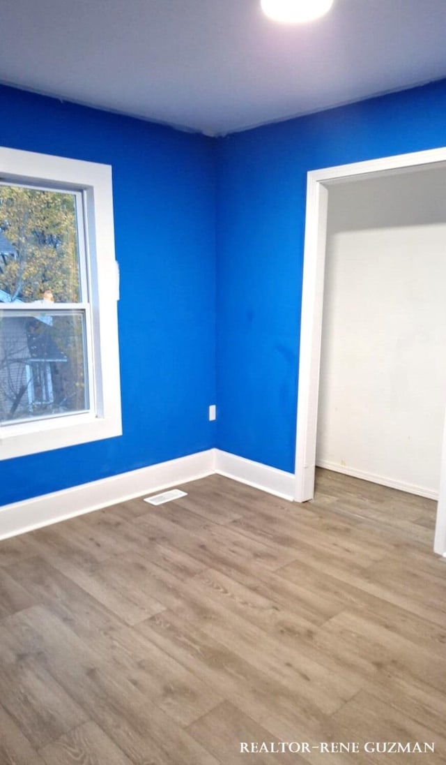 unfurnished room with wood-type flooring