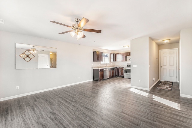 unfurnished living room featuring dark hardwood / wood-style floors, ceiling fan, and sink