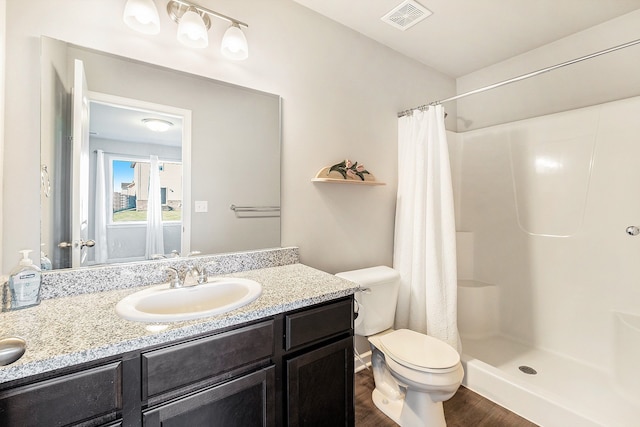 bathroom with a shower with shower curtain, wood-type flooring, vanity, and toilet