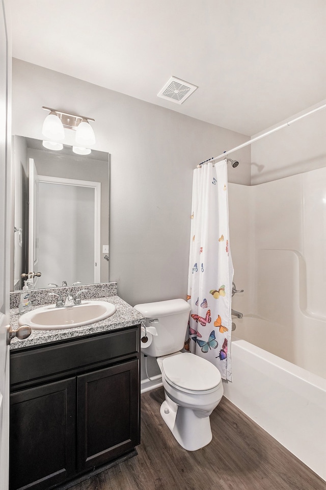 full bathroom with toilet, hardwood / wood-style floors, vanity, and shower / tub combo with curtain