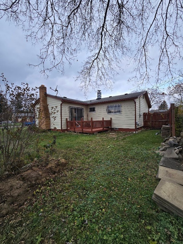 rear view of house with a lawn and a deck