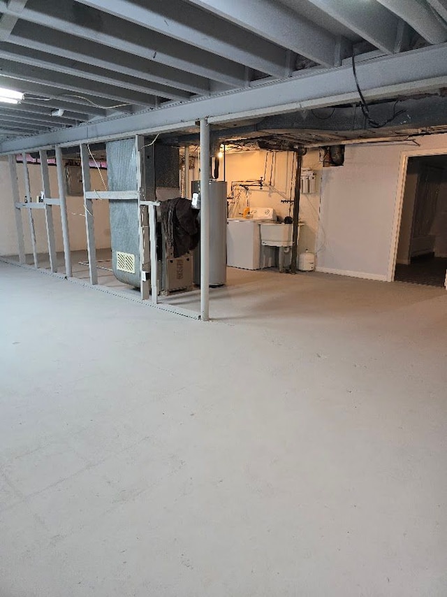 basement with gas water heater, sink, and washing machine and dryer