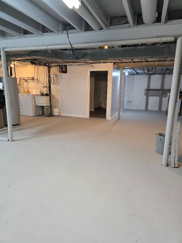 basement featuring gas water heater, sink, and washing machine and dryer