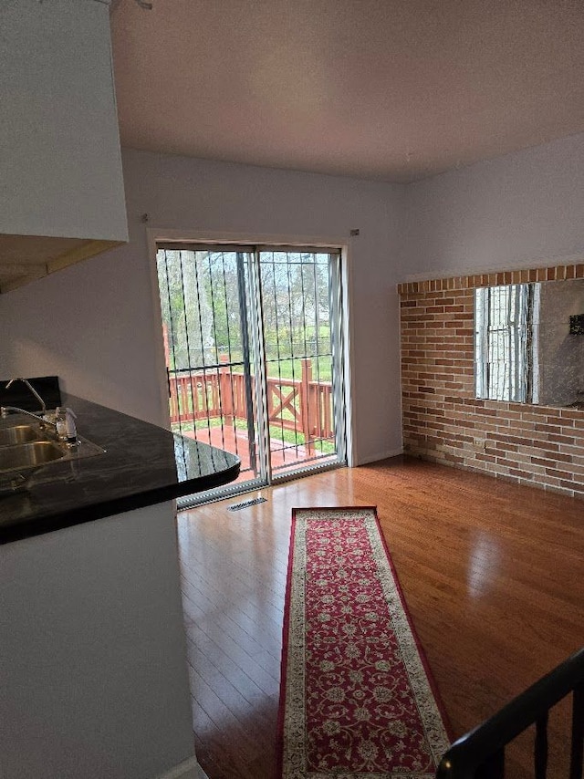 unfurnished living room with sink and hardwood / wood-style flooring