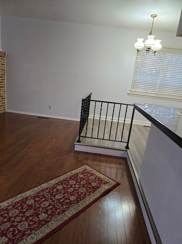 stairway with a chandelier and wood-type flooring