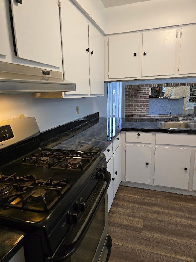 kitchen with white cabinets, sink, dark hardwood / wood-style flooring, and black gas range oven