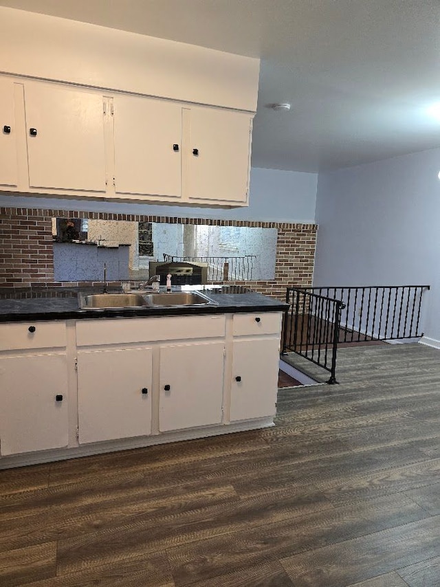 kitchen with tasteful backsplash, sink, white cabinets, and dark hardwood / wood-style floors