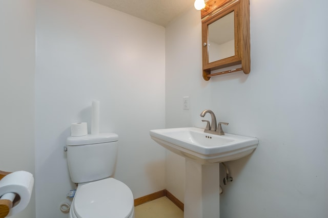 bathroom with sink, a textured ceiling, and toilet