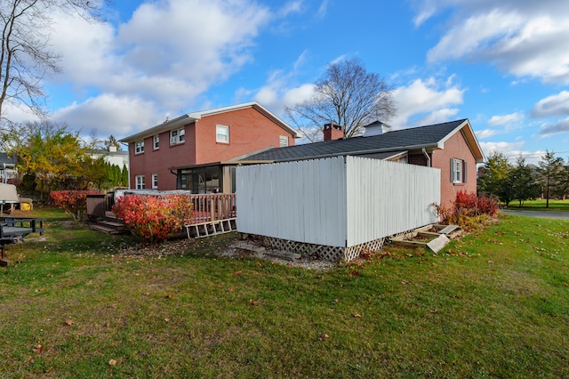 view of side of home featuring a yard and a deck