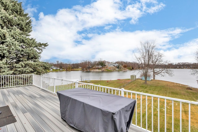 wooden terrace with grilling area, a lawn, and a water view