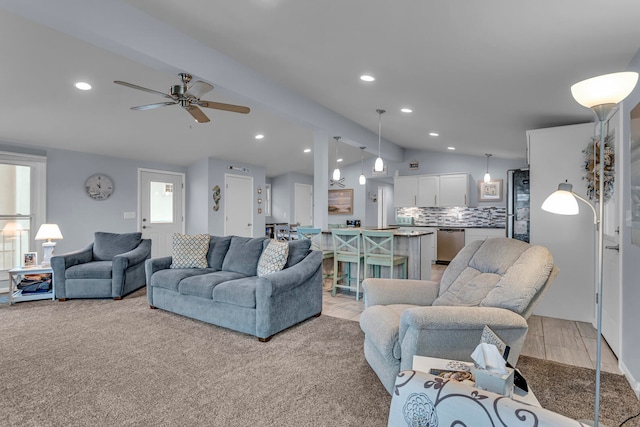 living room featuring vaulted ceiling, light colored carpet, and ceiling fan