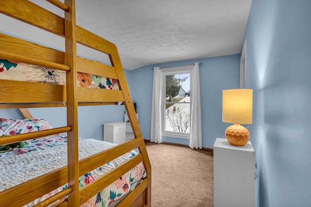 carpeted bedroom with vaulted ceiling and a textured ceiling