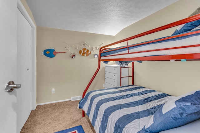 bedroom featuring vaulted ceiling, a textured ceiling, and carpet flooring