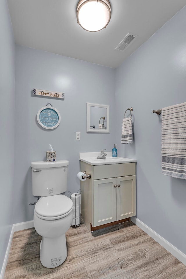 bathroom with vanity, wood-type flooring, and toilet