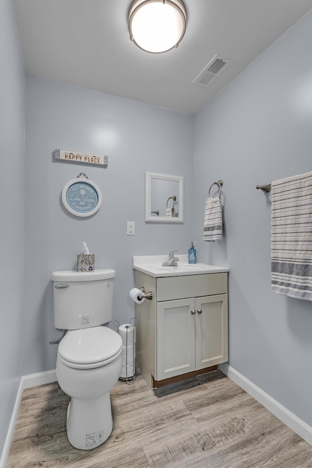 11767 Greenbriar Dr, Jerome, MI 49249 - half bathroom featuring vanity, wood finished floors, toilet, and baseboards