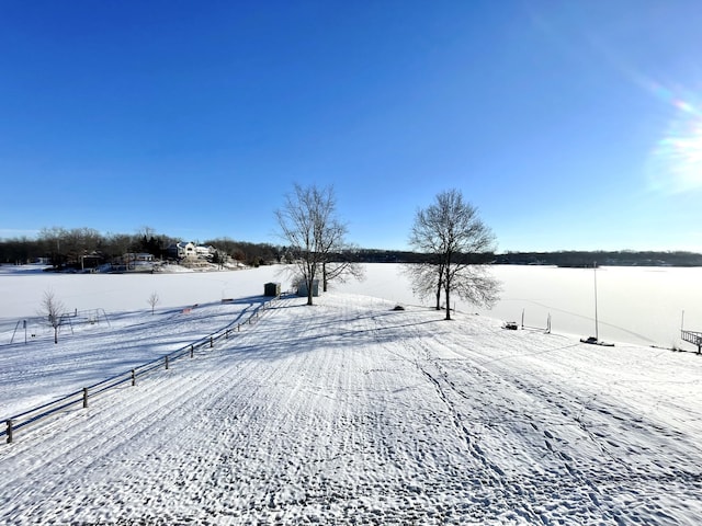 yard covered in snow with a rural view