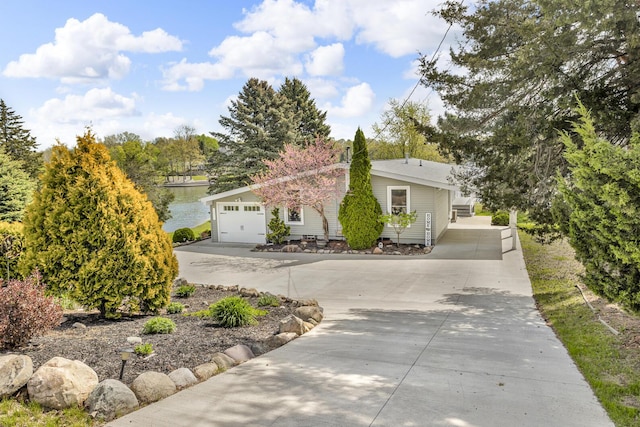 11767 Greenbriar Dr, Jerome, MI 49249 - view of front of property featuring driveway, a water view, and a garage
