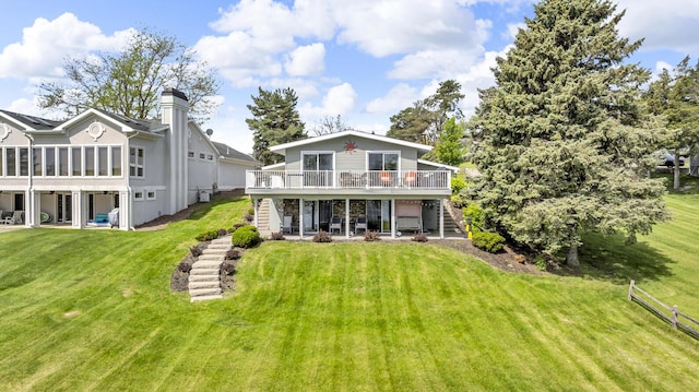 11767 Greenbriar Dr, Jerome, MI 49249 - rear view of property with stairway, a deck, a patio, a lawn, and a chimney