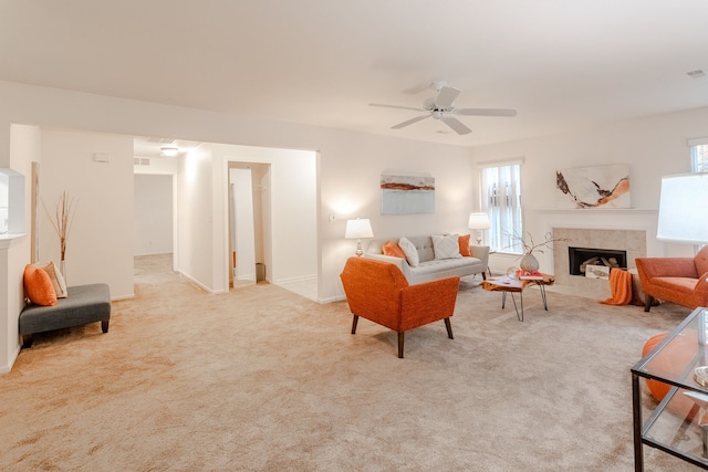 carpeted living room featuring a tile fireplace, a wealth of natural light, and ceiling fan