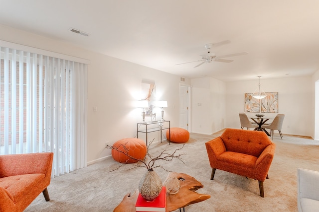 sitting room with ceiling fan and light colored carpet