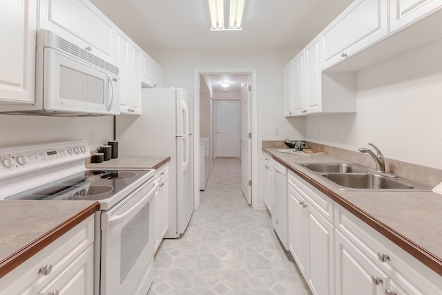 kitchen with light tile patterned floors, white appliances, white cabinetry, and sink