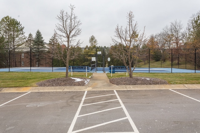 view of parking / parking lot with a lawn and basketball court