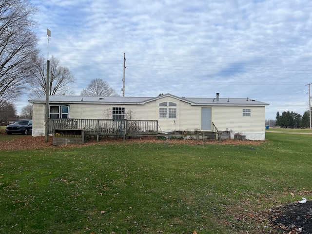 rear view of house with a lawn and a wooden deck