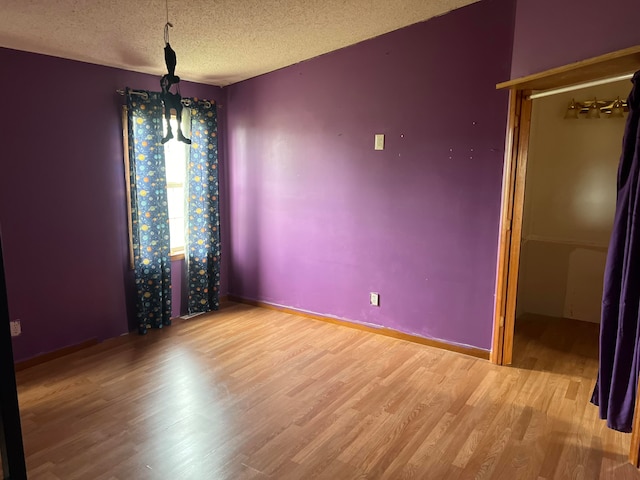 spare room featuring a textured ceiling and hardwood / wood-style flooring