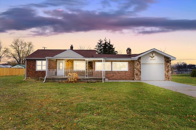 ranch-style home with covered porch, a front yard, concrete driveway, and brick siding